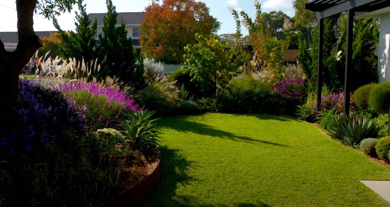 Custom landscape design with colorful plantings and curved lawn